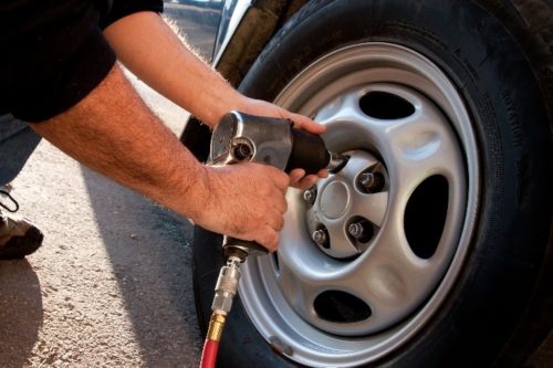 Close on person using air compressor on tire