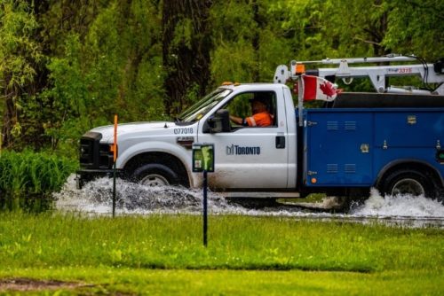 Canadian work truck driving through low water